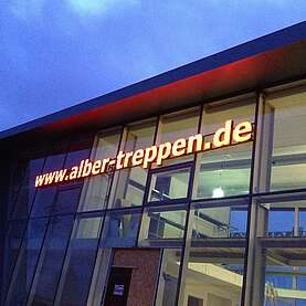 Leuchtschrift, Alber Treppen in Meßkirch, freischwebende Lichtwerbung an Pfosten-Riegel Konstruktion auf Glasfassade montiert. Umsetzung durch ACTIV-Lichtwerbung aus Kernen.  